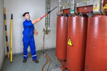 Electrician Engineer using electrical  high voltage detector stick for safety.