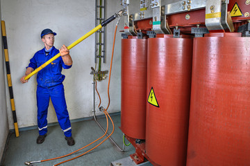 Electrician uses an discharge stick to earth transformer.
