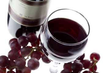 wine served in a glass with grapes on the side.