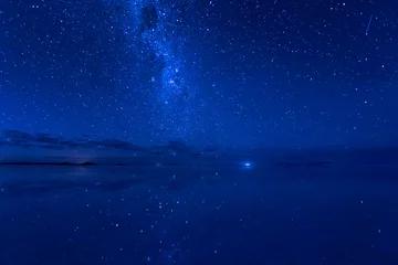  Uyuni, de Melkweg en vallende sterren weerspiegeld op het wateroppervlak. Het Melkwegstelsel en de vallende ster weerspiegelden het wateroppervlak. © Yori Hirokawa