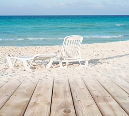 Wooden deck transitioning in to white sandy beach background