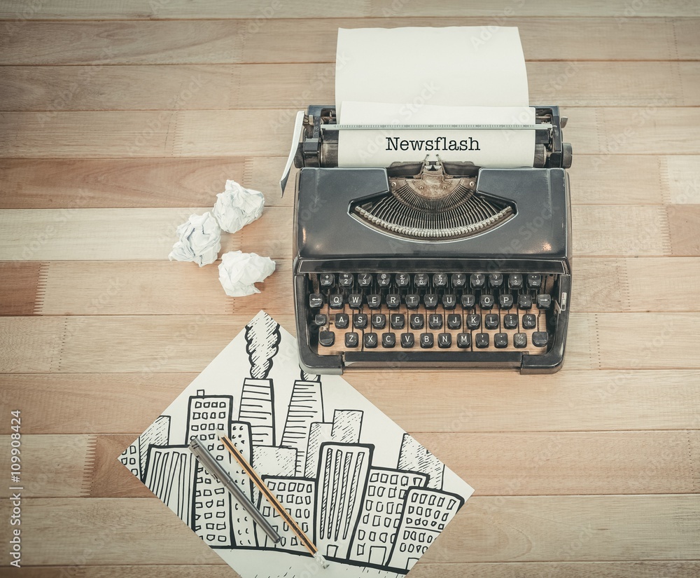 Poster newsflash against typewriter and paper on table in office