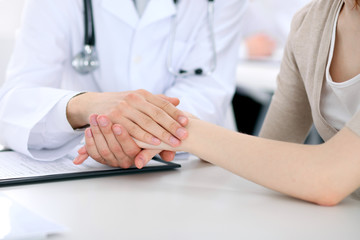 Hand of doctor reassuring her female patient