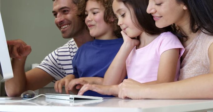Happy family smiling and using a computer together
