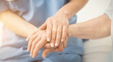 Composite image of nurse holding patient hand