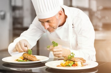 Fototapeta na wymiar Concentrated male chef garnishing food in kitchen