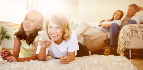 Siblings lying on the floor watching tv