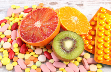 Natural fruits and pills, choice between healthy nutrition and supplements