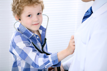 Child patient examining his doctor by stethoscope