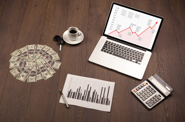 Computer desk with laptop and red arrow chart in screen