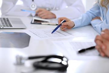 Fototapeta premium Medical doctor and young couple patients discussing something at the table . Hands close-up