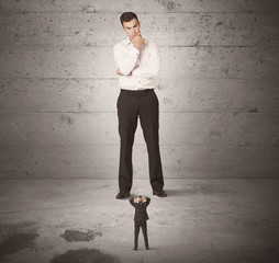 Huge business guy looking at small coworker