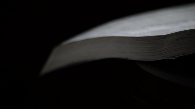 Page of phone book with names and address rotating in a black background