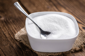 White Sugar (selective focus) on wooden background