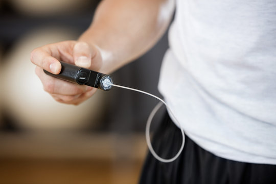 Midsection Of Man Using Glucose Monitor In Gym