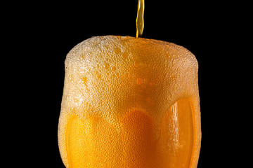 Orange soda large glass, overflowing glass of orange soda closeup with bubbles isolated on black...