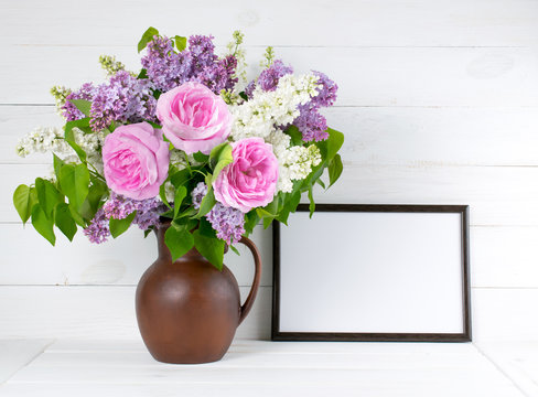 Lilac and roses in clay jug with motivational frame in scandinav