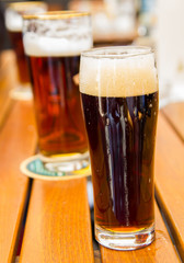 Glass of dark beer on wooden table