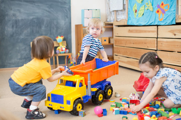 two kids conflict or struggling for toy truck in kindergarten