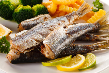 Fried herrings, chips and vegetables
