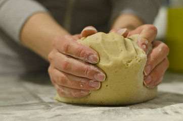Female hands in flour closeup kneading dough