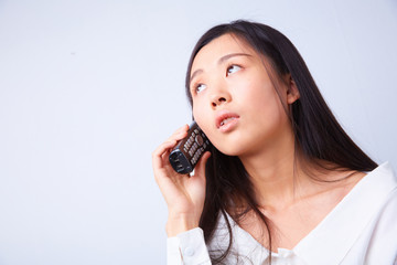 sad Chinese woman talking on a phone