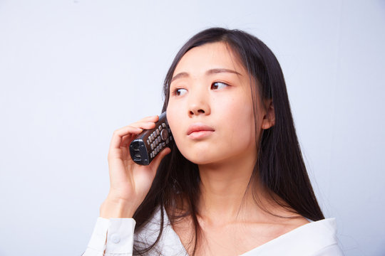 sad Chinese woman talking on a phone