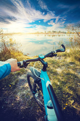 Man riding on a bicycle near the lake