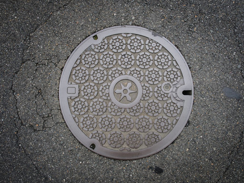 Circle steel manhole cover on asphalt street
