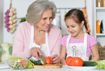 Senior woman with granddaughter cooking