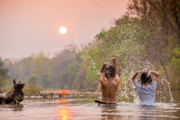 asian boy and girl playing in the river
