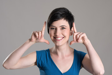 Studio portrait of young short hair beauty with finger frame gesture