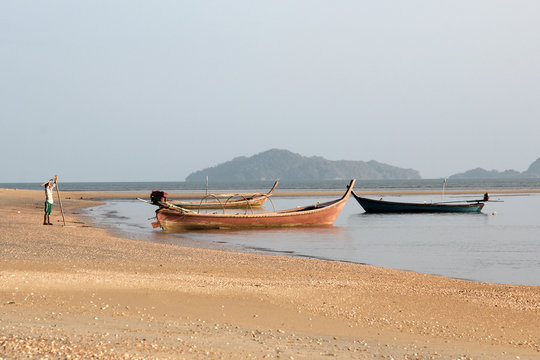 Thai fishing boats in the sea on a background of mountains 
a fishing village