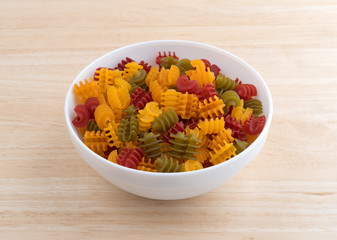 Corn vegetable radiatore pasta in a bowl on wood table top side view