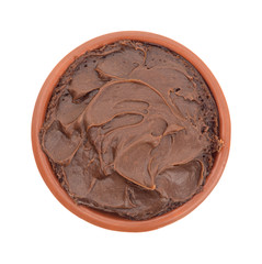 Chocolate fudge frosting in a small bowl top view on a white background