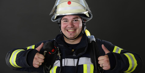 Feuerwehrmann zeigt Daumen in Arbeitskleidung