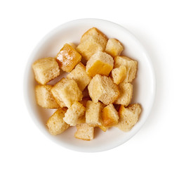 Bowl of croutons isolated on white, top view