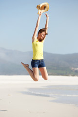 Obraz premium Excited young woman jumping on the beach