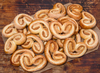 Puff sweet pretzels with cinnamon  on the dark brown wooden background