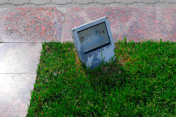 Garden light in the grass by granite stone footpath