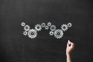 girl drawing gears on blackboard