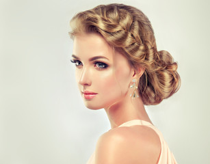 Fototapeta premium Beautiful model girl with elegant hairstyle . Beautiy woman with fashion wedding hair and colourful makeup 