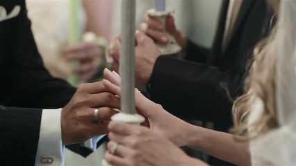Greek and Bulgarian Orthodox Church rituals traditions and customs. Koumbaro best man puts rings on half finger of groom and bride hands - exchanging wedding rings between marrying couple. Close up
