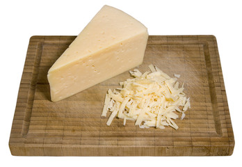 Shredded cheese and a piece of cheese on the bamboo cutting board isolated on white background