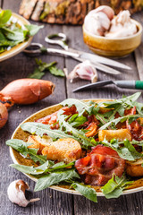 Fresh dandelion salad with fried bacon and garlic croutons.