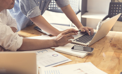 people working with laptop computer and business document