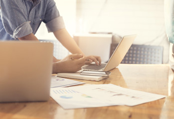 people working with laptop computer and business document