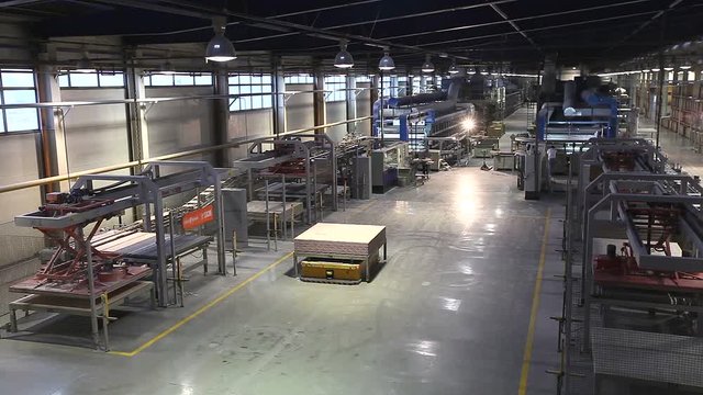 Autonomous mobile robots transport products in a large modern factory. Ceramic tiles manufacturing , Ceramics Plant, truck transports