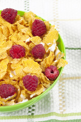 corn flakes bowl with raspberries on a table mat