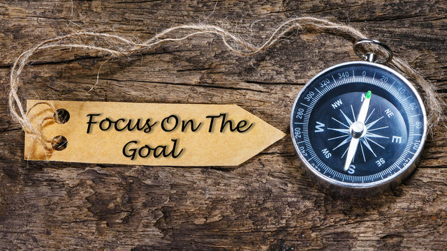 Focus on the goal - Motivation handwriting on label with compass